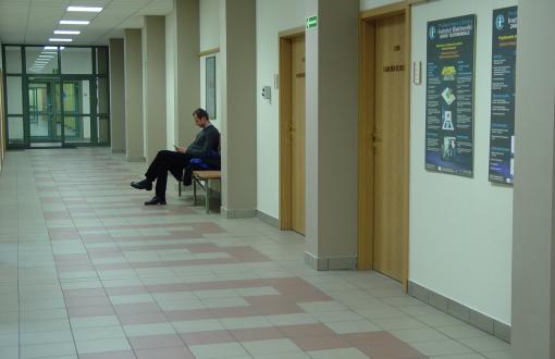 Student siedzący na ławce na korytarzu.